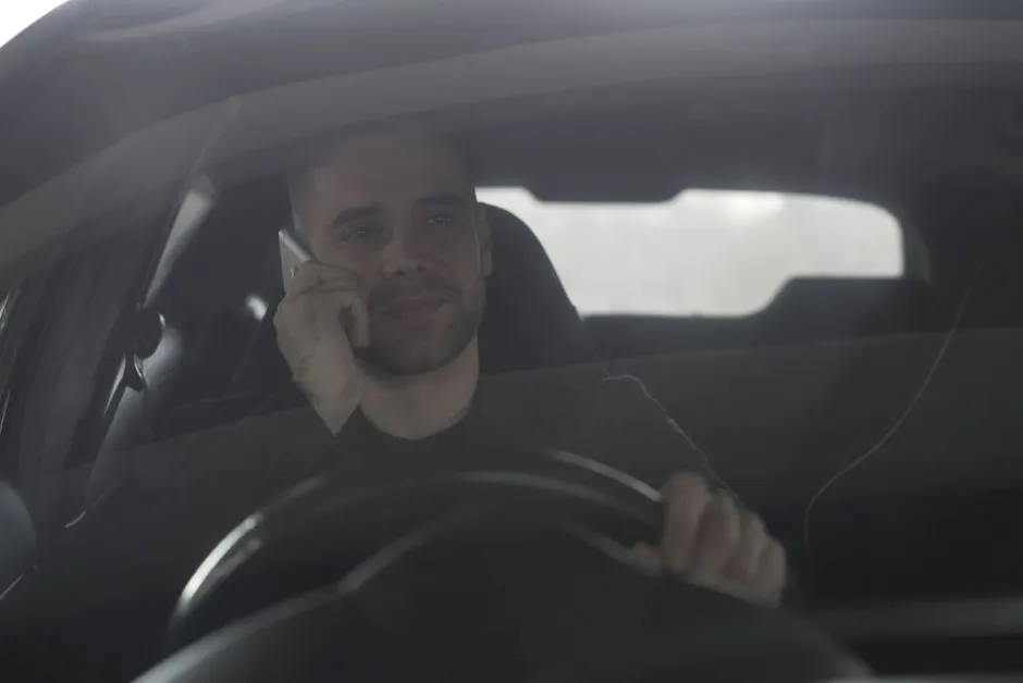 Mécanicien qui écoute un bruit sous une voiture sur un pont élévateur
